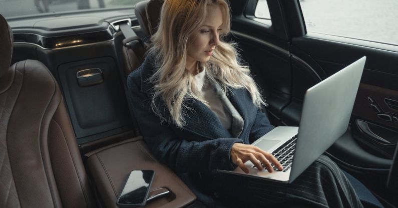 Travel Gadgets - Woman in Blue Coat Sitting on Car Seat