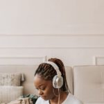 Clothes Packing - A Woman Wearing Her Headphones and Using Her Laptop