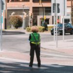 Adapter Guide - A person standing on a street corner with a green jacket