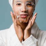 Recovery Essentials - Black woman after spa applying sheet mask