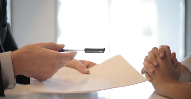 Returns Policy - Crop businessman giving contract to woman to sign