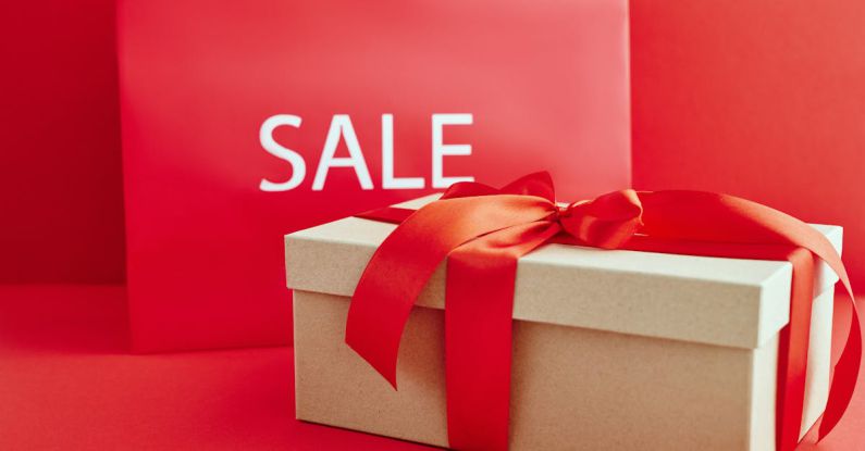 Luxury Bargain - Cardboard Box with Red Ribbon Beside A Sale Sign