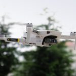 Drone Flying - A white drone flying over a city street