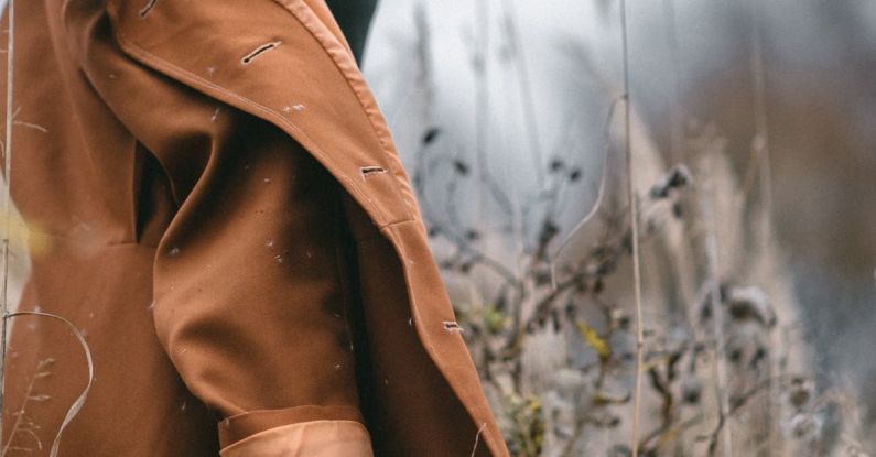 Eco Fashion - Stylish woman in trendy coat in field with dry grass