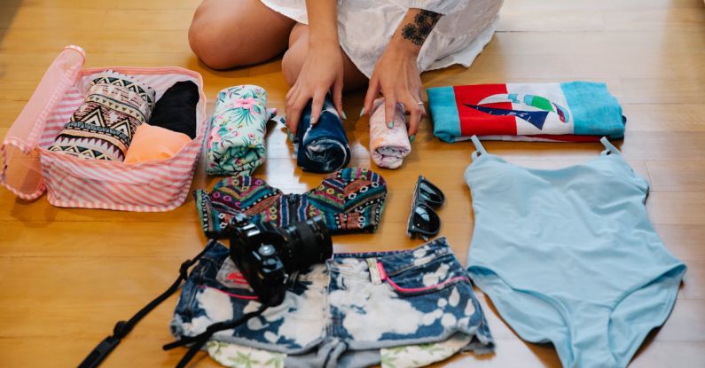 Travel Essentials - A Person Sitting on a Wooden Floor while Preparing Travel Essentials