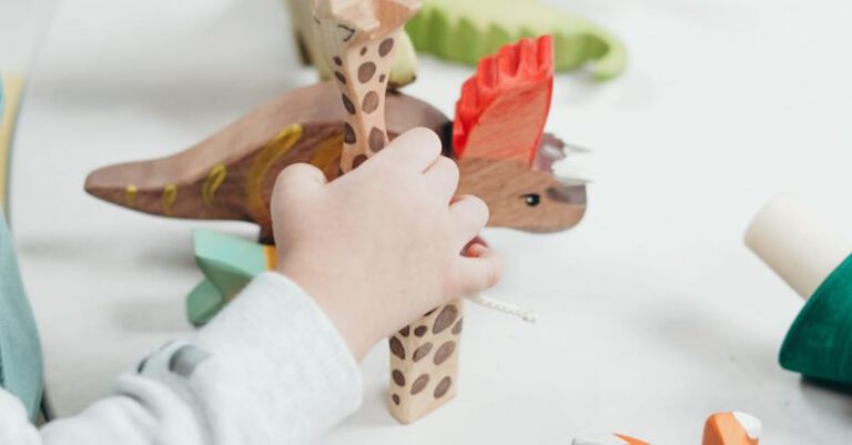 Kids Learning Toys - Child Holding Brown and Green Wooden Animal Toys