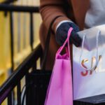 Spring Sale - Crop faceless woman looking in shopping bags on spring street