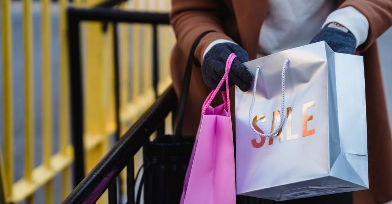 Spring Sale - Crop faceless woman looking in shopping bags on spring street