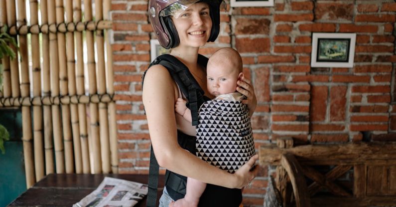 Baby Gear - Woman Wearing Brown Helmet While Carrying Her Baby
