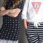 Kids Fashion - Girl in Black Dress Standing Beside Girl in White Sweatshirt and Black Striped Pants