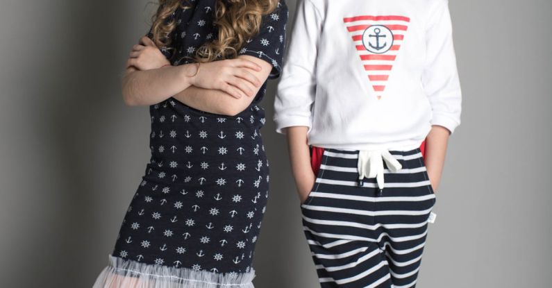 Kids Fashion - Girl in Black Dress Standing Beside Girl in White Sweatshirt and Black Striped Pants